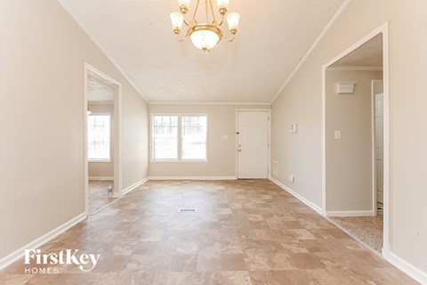 the spacious living room and dining room with a chandelier