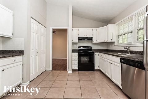 A kitchen with white cabinets and a black oven.