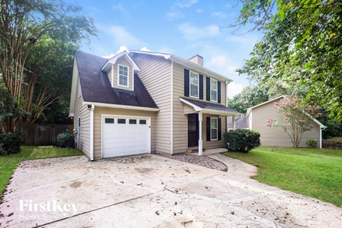 A two-story house with a garage is for sale.