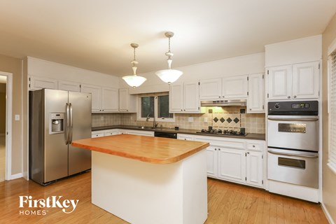 A kitchen with a wooden island and stainless steel appliances.