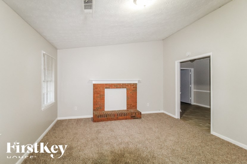 a living room with a fireplace and a door to a hallway