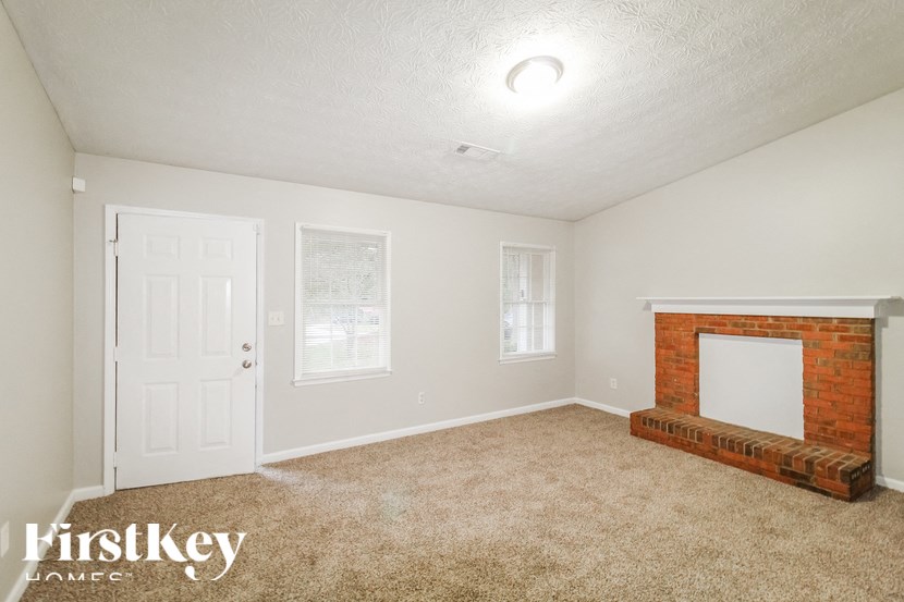 a living room with a brick fireplace and a white door