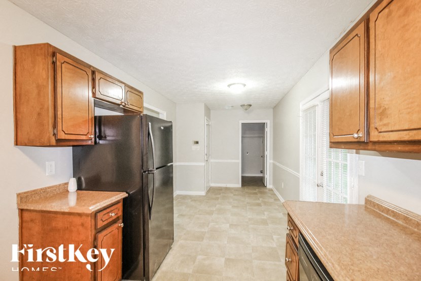a kitchen with wooden cabinets and a black refrigerator