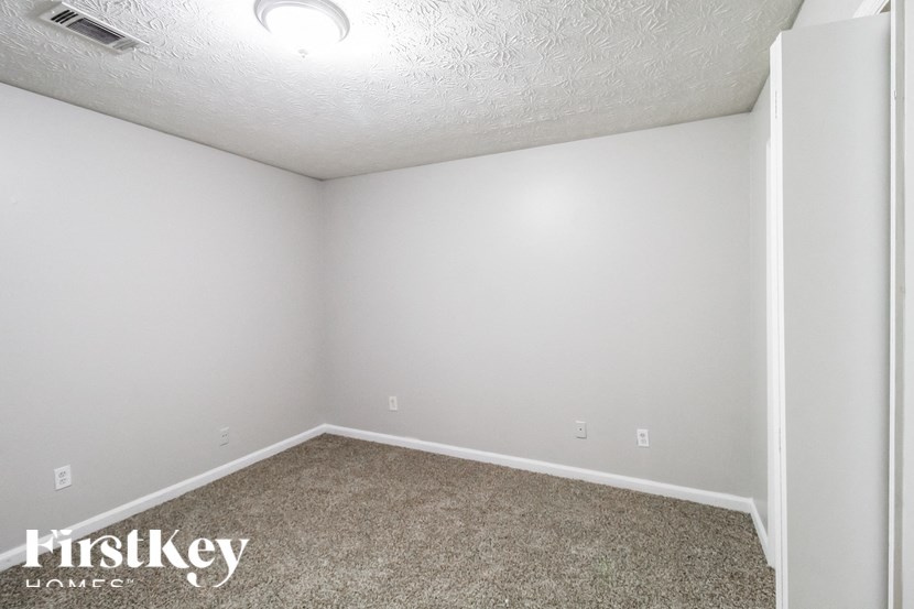 the upstairs bedroom of an apartment with carpet and white walls