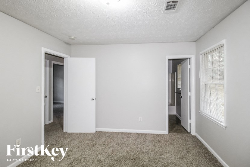 a bedroom with a carpeted floor and white walls