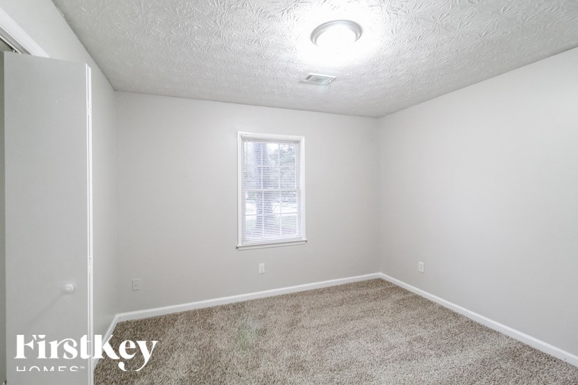 a bedroom with a carpeted floor and a window