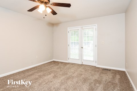 a living room with carpet and a ceiling fan