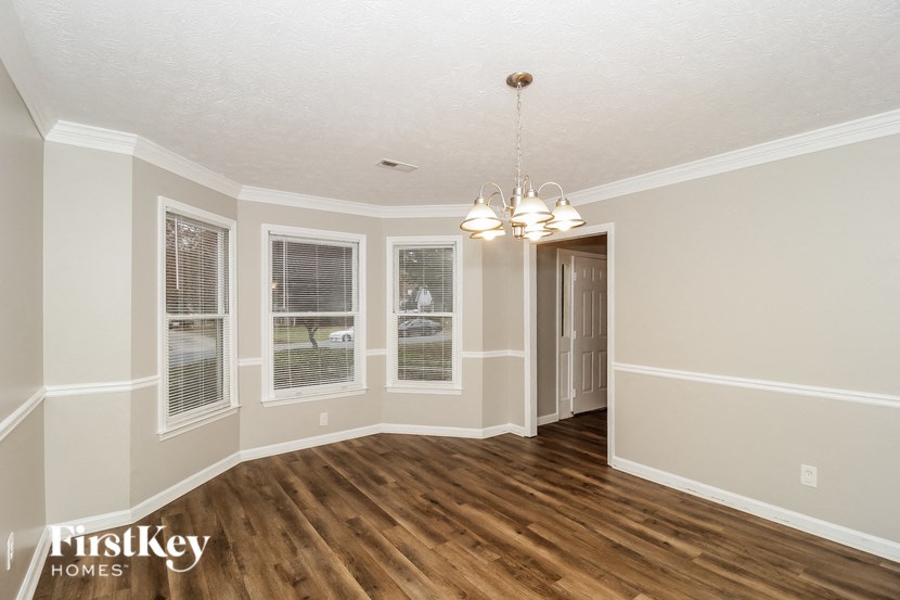 an empty living room with a wood floor and white walls
