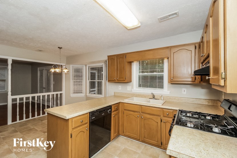 a kitchen with wooden cabinets and a sink and a stove