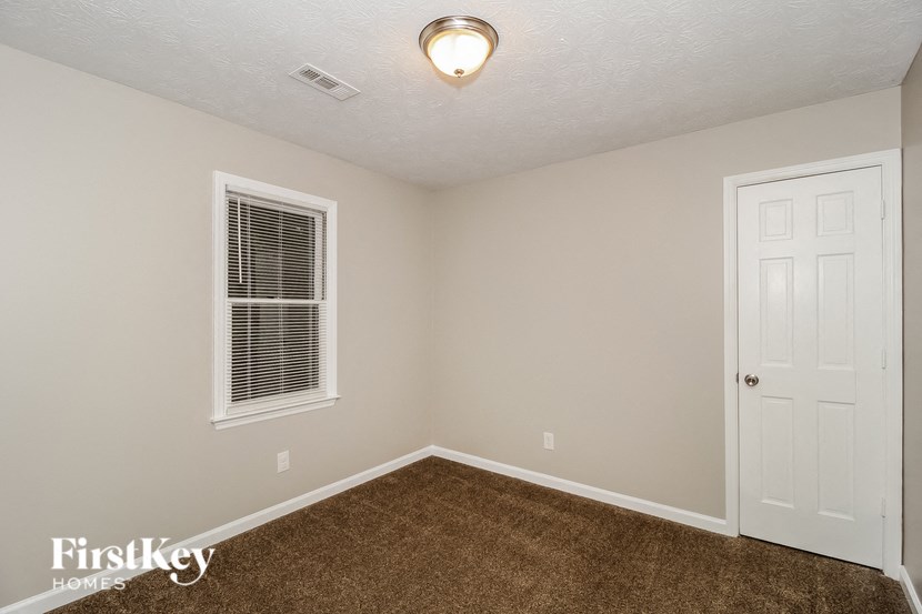 a bedroom with a carpeted floor and a white door