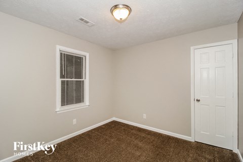 a bedroom with a carpeted floor and a white door