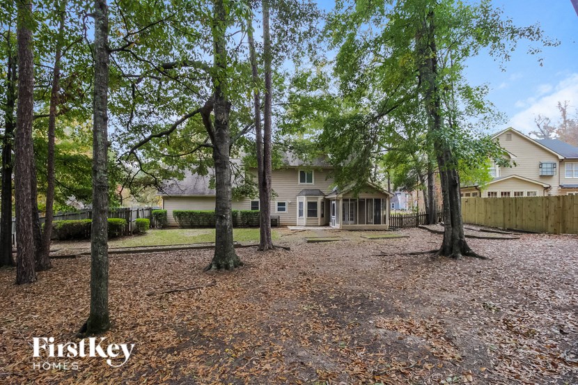a yard with trees and a house in the background