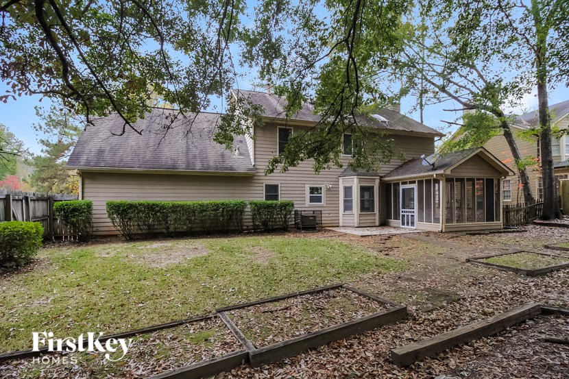 a house with a yard and a fence in front of it