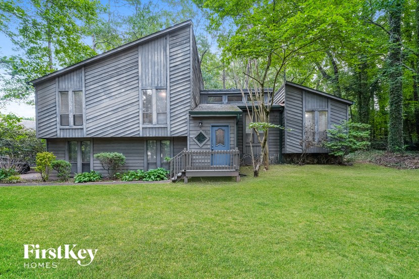 a gray house with a yard and a blue door