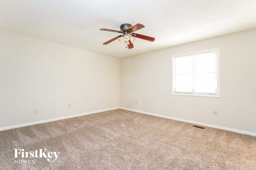 a bedroom with carpet and a ceiling fan
