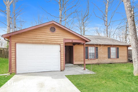 a wood sided home with a white garage door