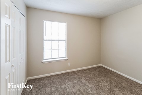 a bedroom with carpet and a window