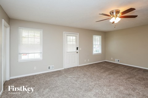 the master bedroom has a carpeted floor and a ceiling fan