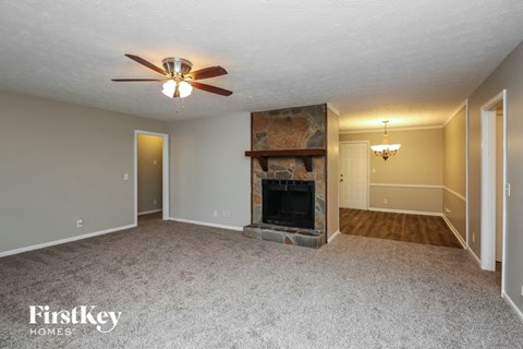 a living room with a fireplace and a ceiling fan
