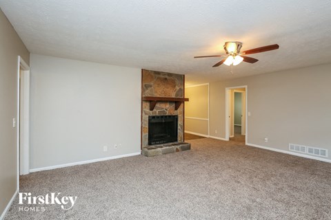 a living room with a fireplace and a ceiling fan
