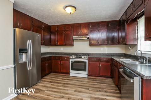 a kitchen with wooden cabinets and stainless steel appliances