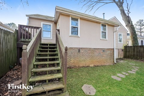 the exterior of a home with stairs and a wooden deck
