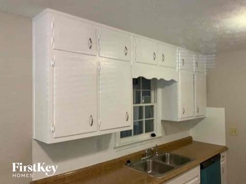an empty kitchen with white cabinets and a sink