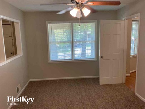 a room with a ceiling fan and a door and a window