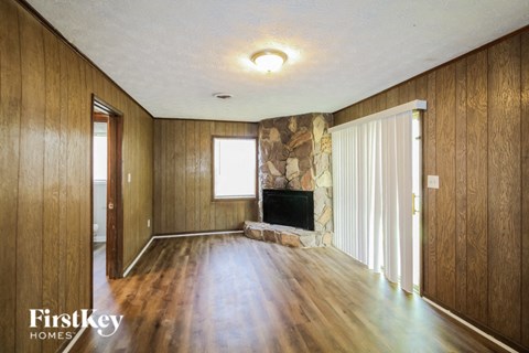 an empty living room with wood floors and a fireplace