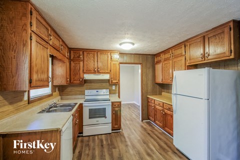 a kitchen with wooden cabinets and white appliances and a refrigerator