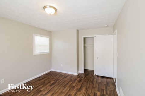 the living room with hardwood flooring and a white door to the closet