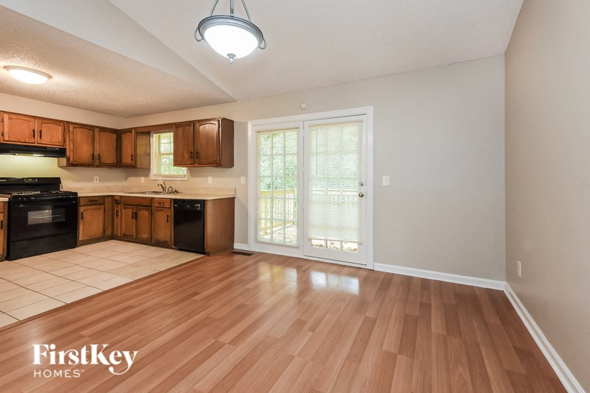 an empty kitchen and living room with wood flooring and a window