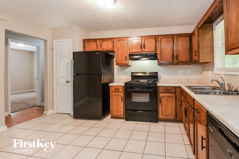 a kitchen with black appliances and wooden cabinets