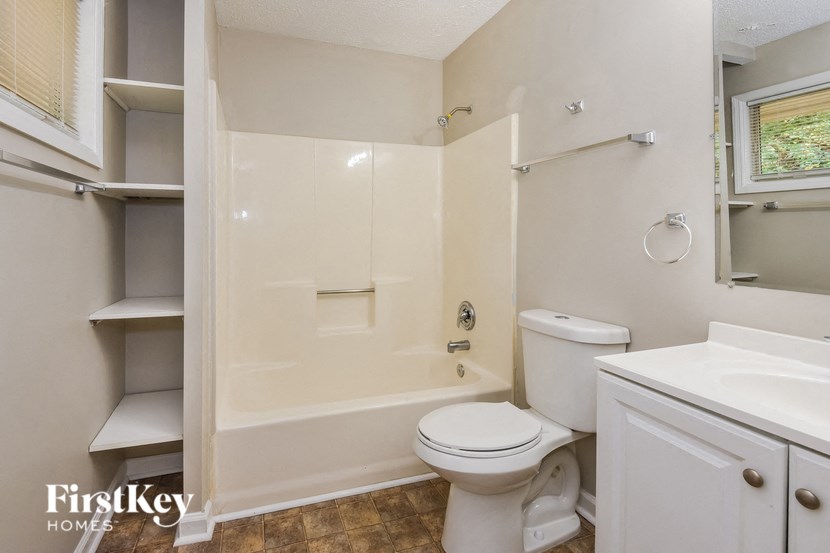 a bathroom with a toilet and a tub and a sink