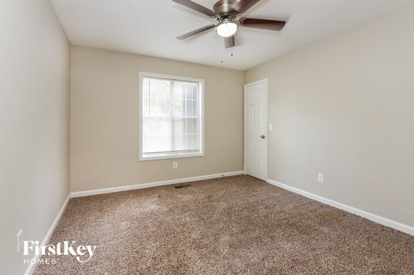 an empty room with a ceiling fan and a window