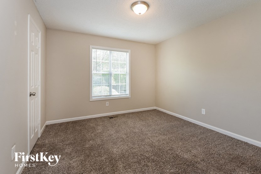 an empty room with carpet and a window