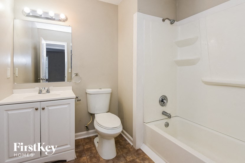 a white bathroom with a toilet and a tub and a sink