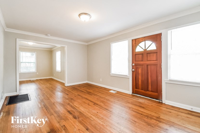 an empty living room with wood floors and a wooden door