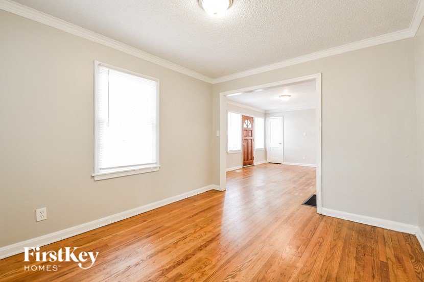 the living room and dining room with hardwood flooring and a window