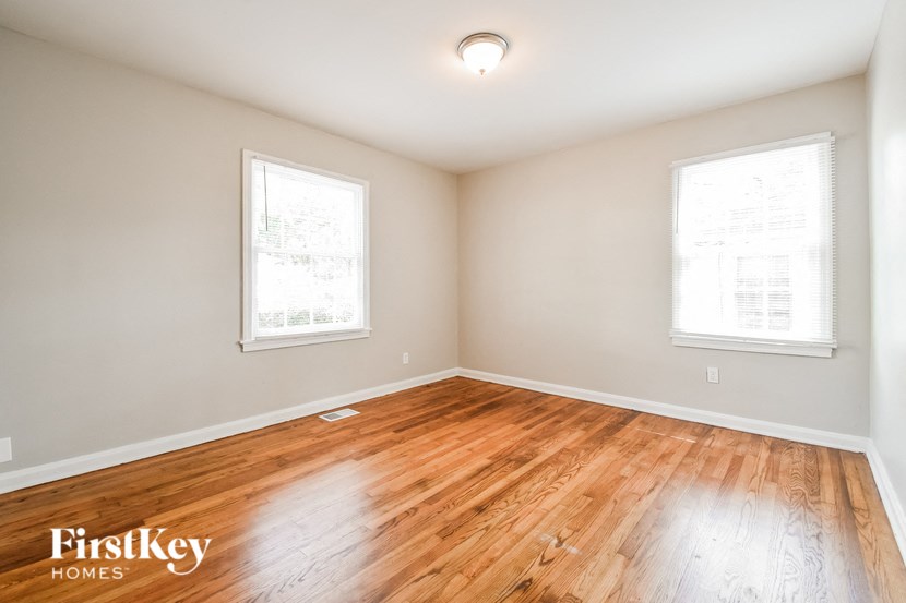 the living room with hardwood flooring and two windows