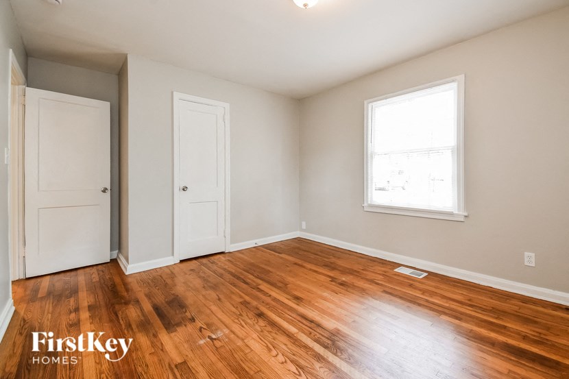 the living room of an empty house with wood floors and a window