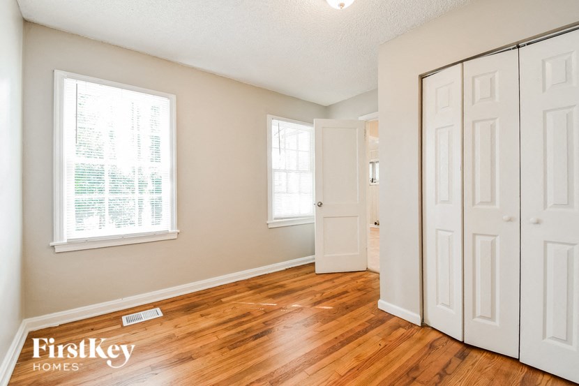 the living room of a home with wood floors and white doors