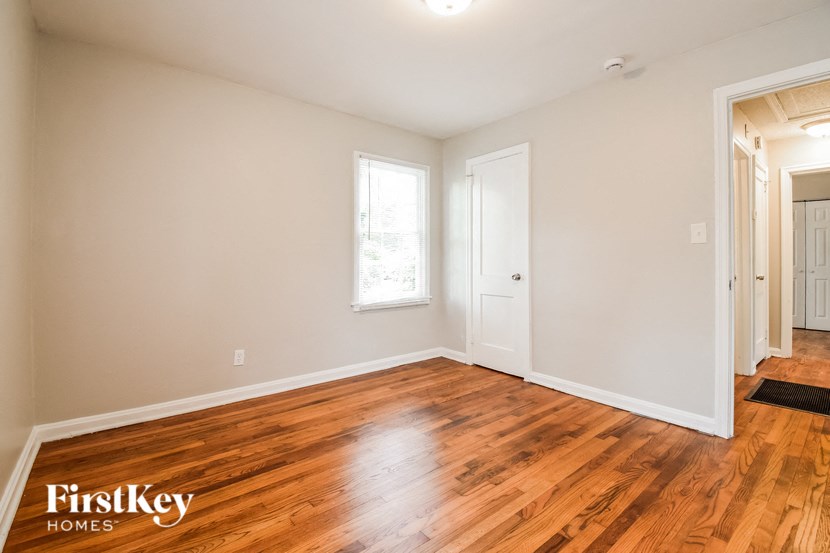the living room and dining room of a house with wood floors and white walls
