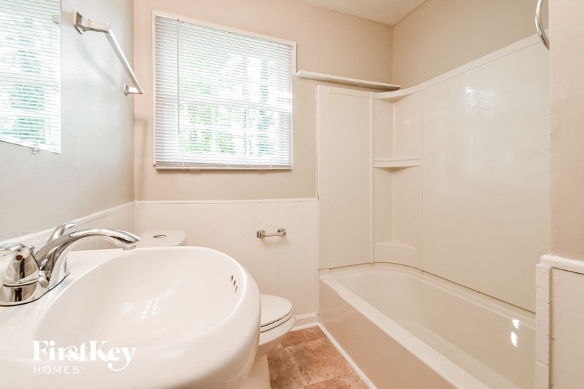 a bathroom with a sink and a bath tub and a window