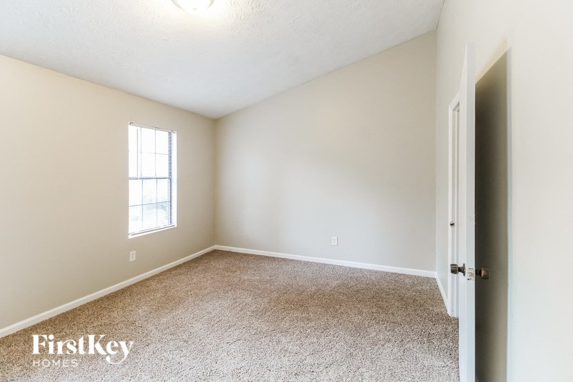 a bedroom with a carpeted floor and a window