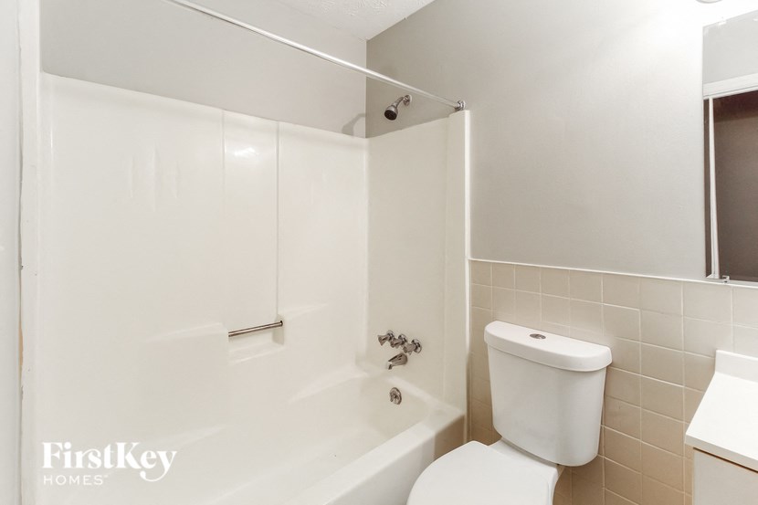 a bathroom with a white toilet and a tub and a sink