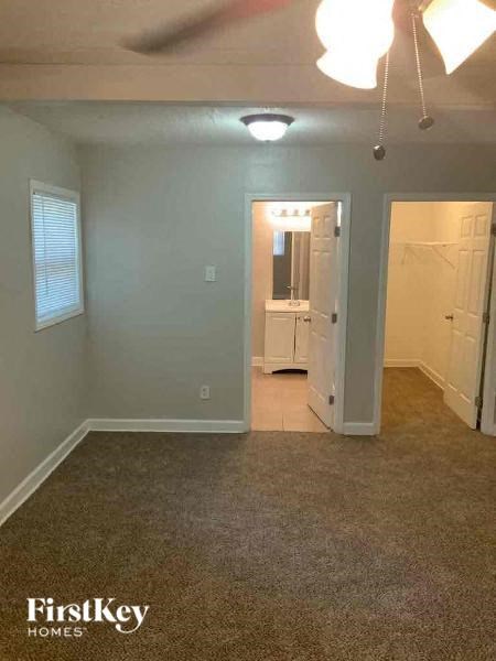 an empty living room with a door to a bathroom