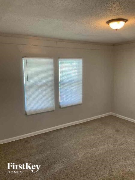 an empty room with two windows and a light on the ceiling