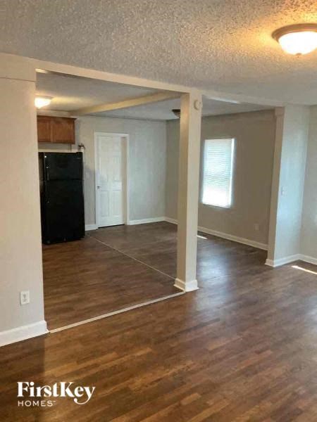 an empty living room with a hard wood floor