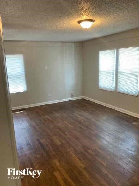 an empty living room with a hard wood floor
